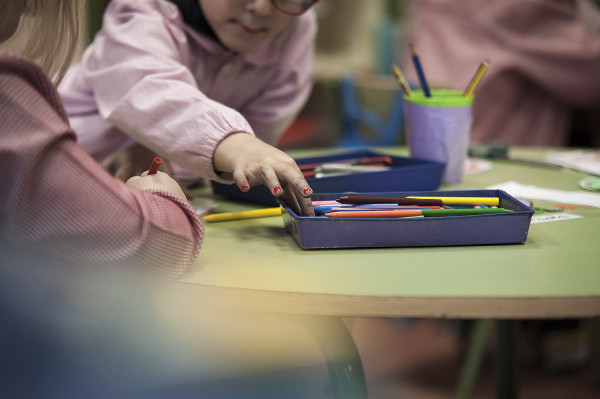 imagen de dos niños/s en una mesa con lápices de colores