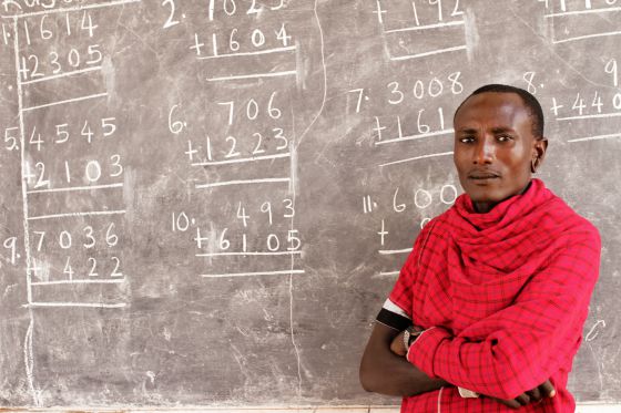 Imagen de un guerrero masai ante una pizarra llena de números