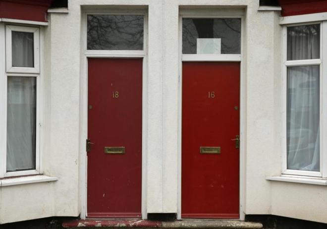 Foto de la puerta pintada de rojo de dos casas contiguas