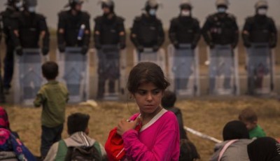 Una joven refugiada y policías al fondo