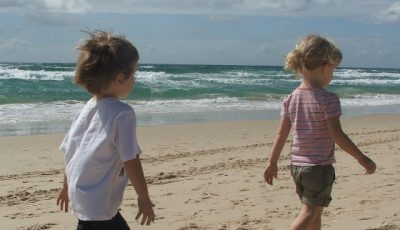 Imagen de dos niños caminando por la playa