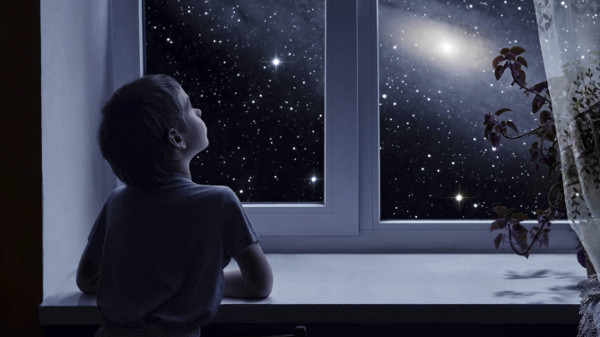 Imagen de un niño mirando un cielo nocturno