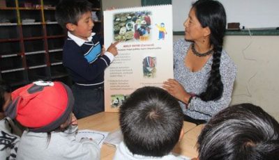 Imagen de una maestra y un alumno indígenas