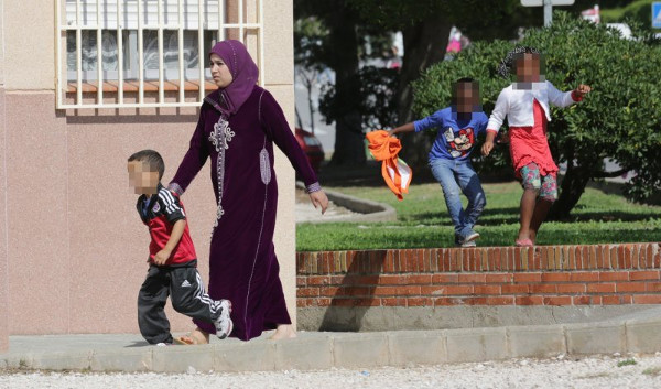 una musulmana con un niño de la mano