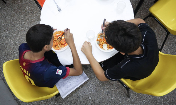 imagen de dos niños comiendo en una mesa