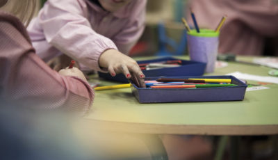 imagen de dos niños/s en una mesa con lápices de colores