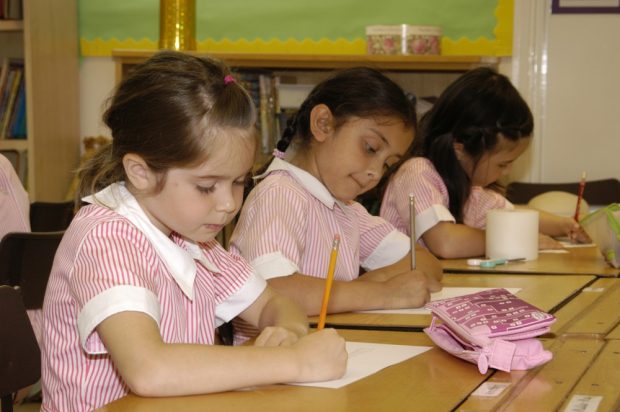 Tres niñas con uniformes de colegio rosas
