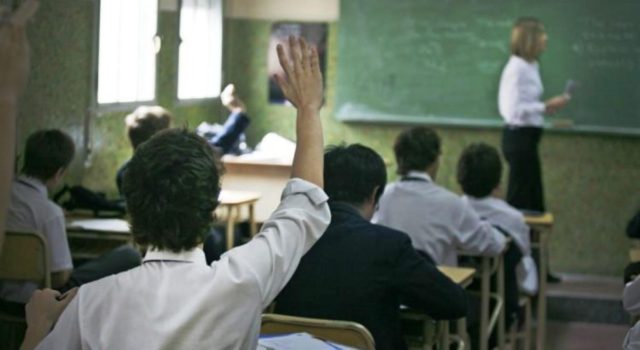un alumno alza la mano en una clase