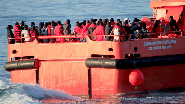 imagen de un grupo de inmigrantes en la cubierta de una barcaza de rescate