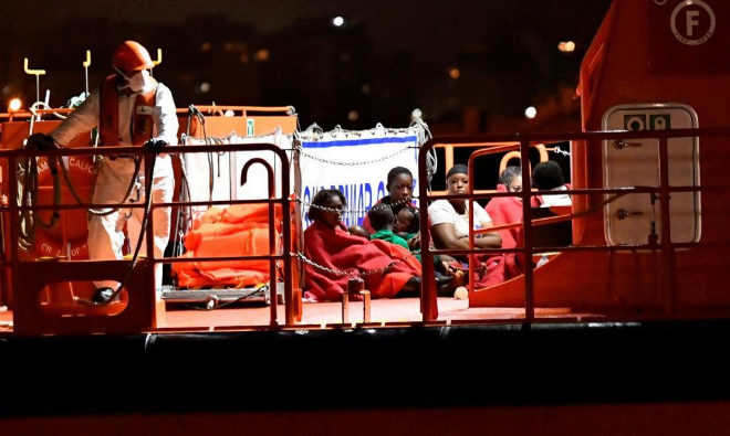 un grupo de inmigrantes en la cubierta de un barco de noche