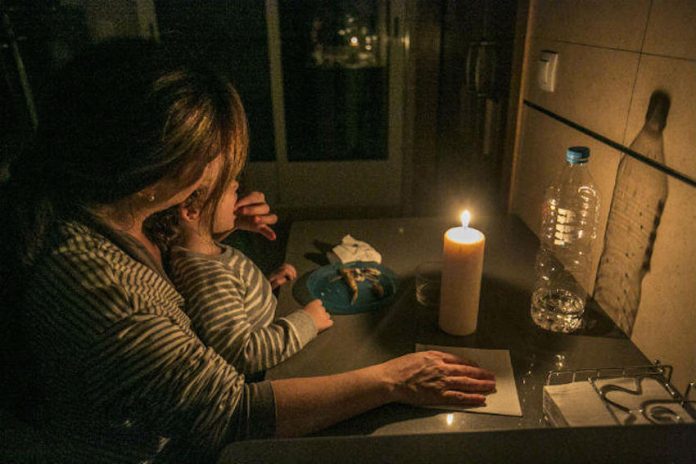 imagen de una madre con un hijo/a alumbrándose con una vela