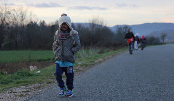 imagen de un niño inmigrante andando por una carretera