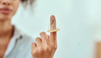 imagen de una joven con un preservativo en la mano