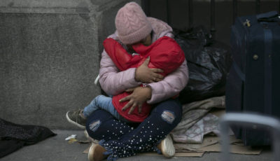 una mujer con un niño en la calle a las puertas del Samur Social de Madrid