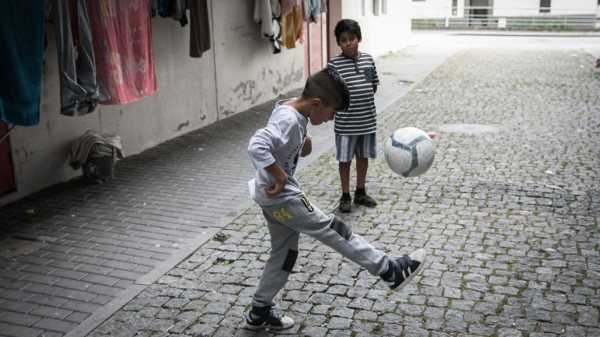 dos niños romaníes juegan al balón