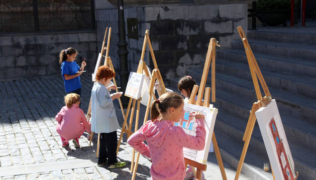 unos niños pintando en la calle