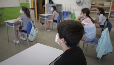 un grupo de niños y niñas asiste a clase con mascarilla