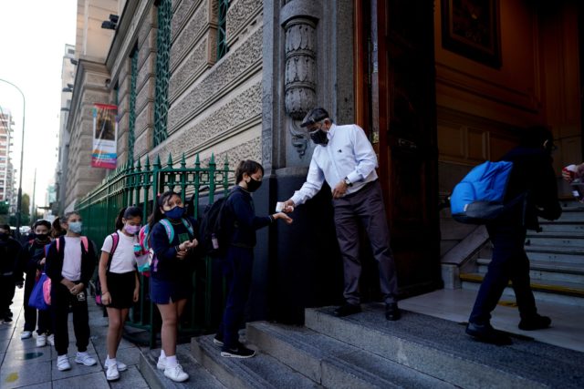 una persona toma la temperatura a la entrada de un colegio en Buenos Aires