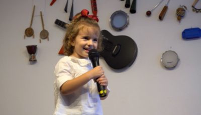 una niña canta con un micrófono